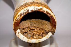 The end of the toilet pipe, half of the diameter of which is clogged with deposits of urine. The problem is to flush the feces, water is poured over the edges of the toilet. Urine stone .Dirty toilet.